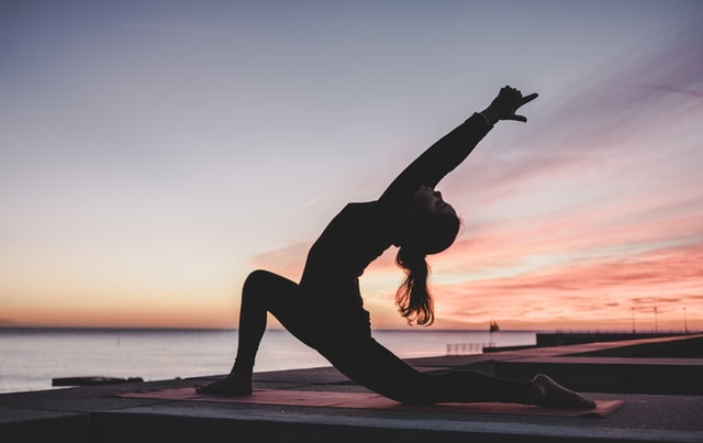 Persona en pose de yoga al atardecer